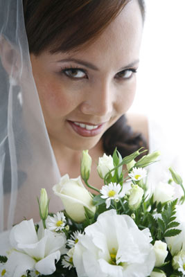 Magazine style fashion photoshoot in Orange County. Portrait of the Bride in her wedding dress and veil looking up at the camera with her bouquet.