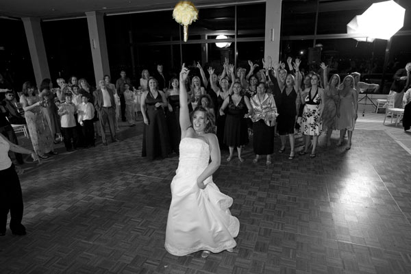 Photojournalistic photo of a wedding reception in Los Angeles bride is tossing her bouquet.